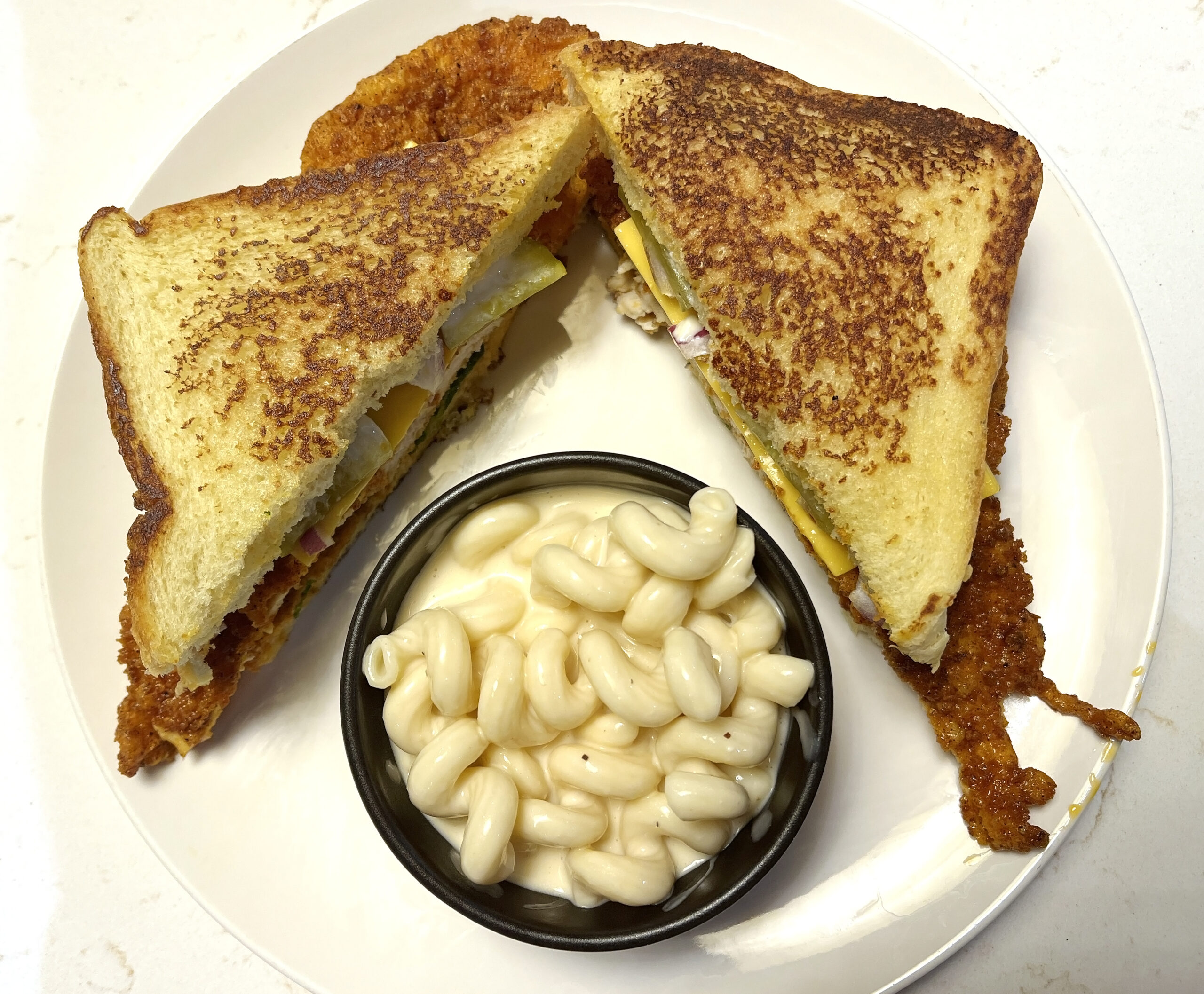 Nashville Hot Chicken Sandwich prepared by Jonny O's is served with homemade macaroni and cheese.