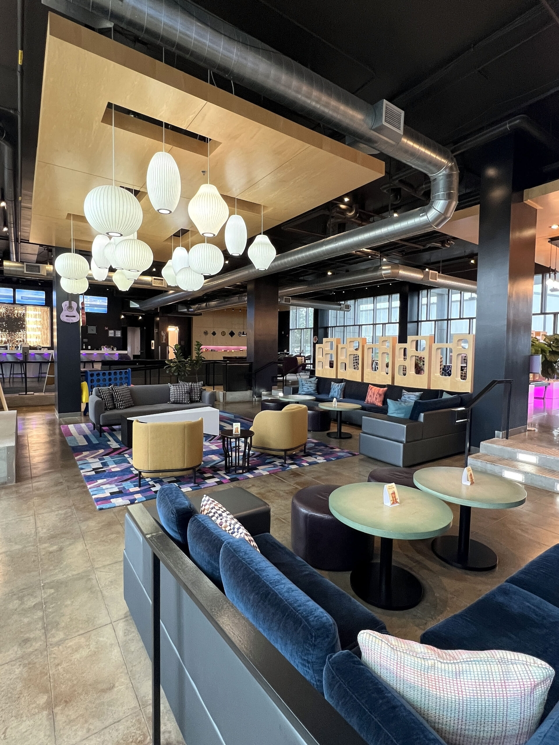 The Aloft Wichita hotel lobby is an inviting space with various seating areas for leisure and business travelers.