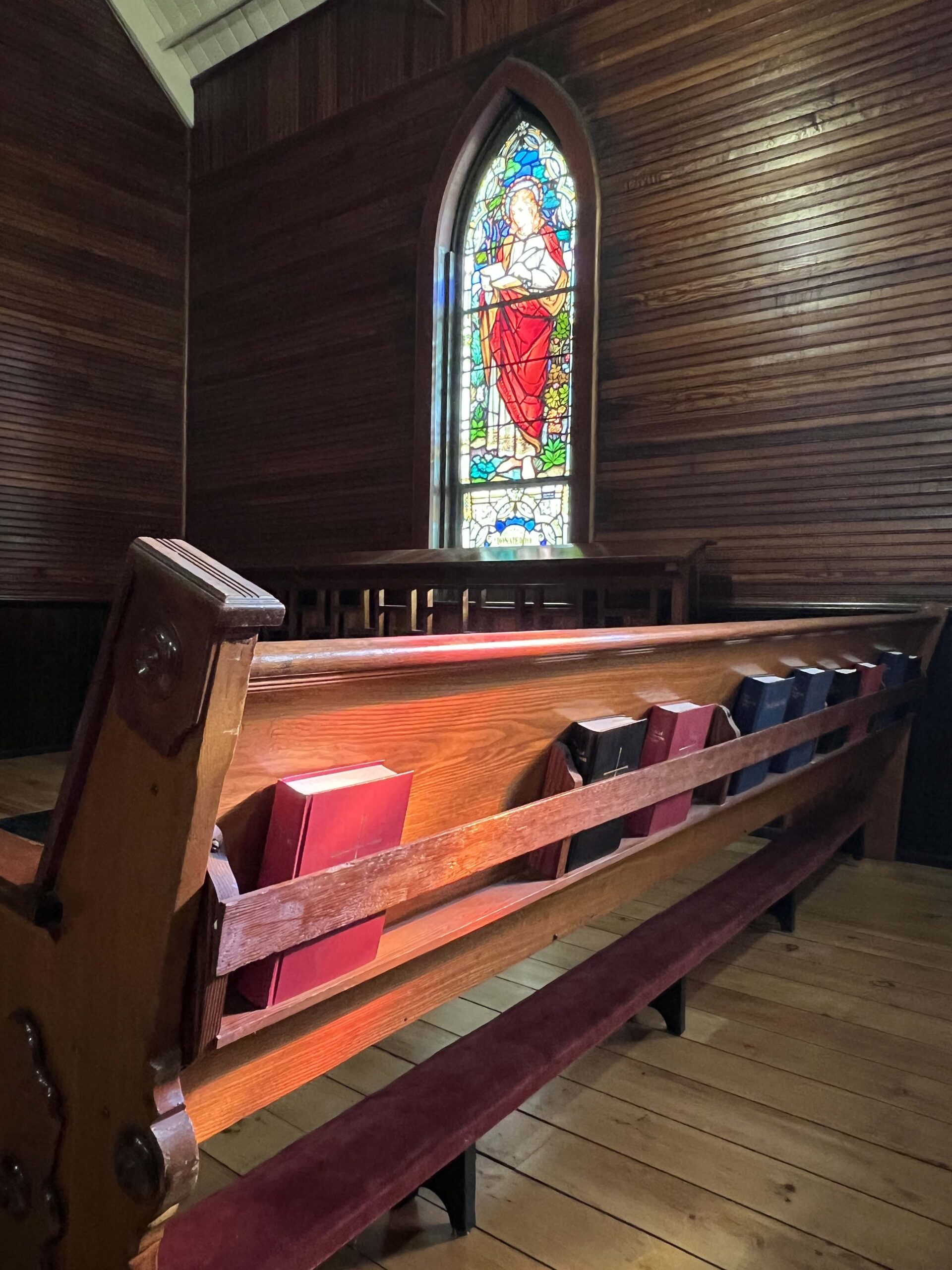 Painted windows illuminate the pews inside Grace Episcopal Church.