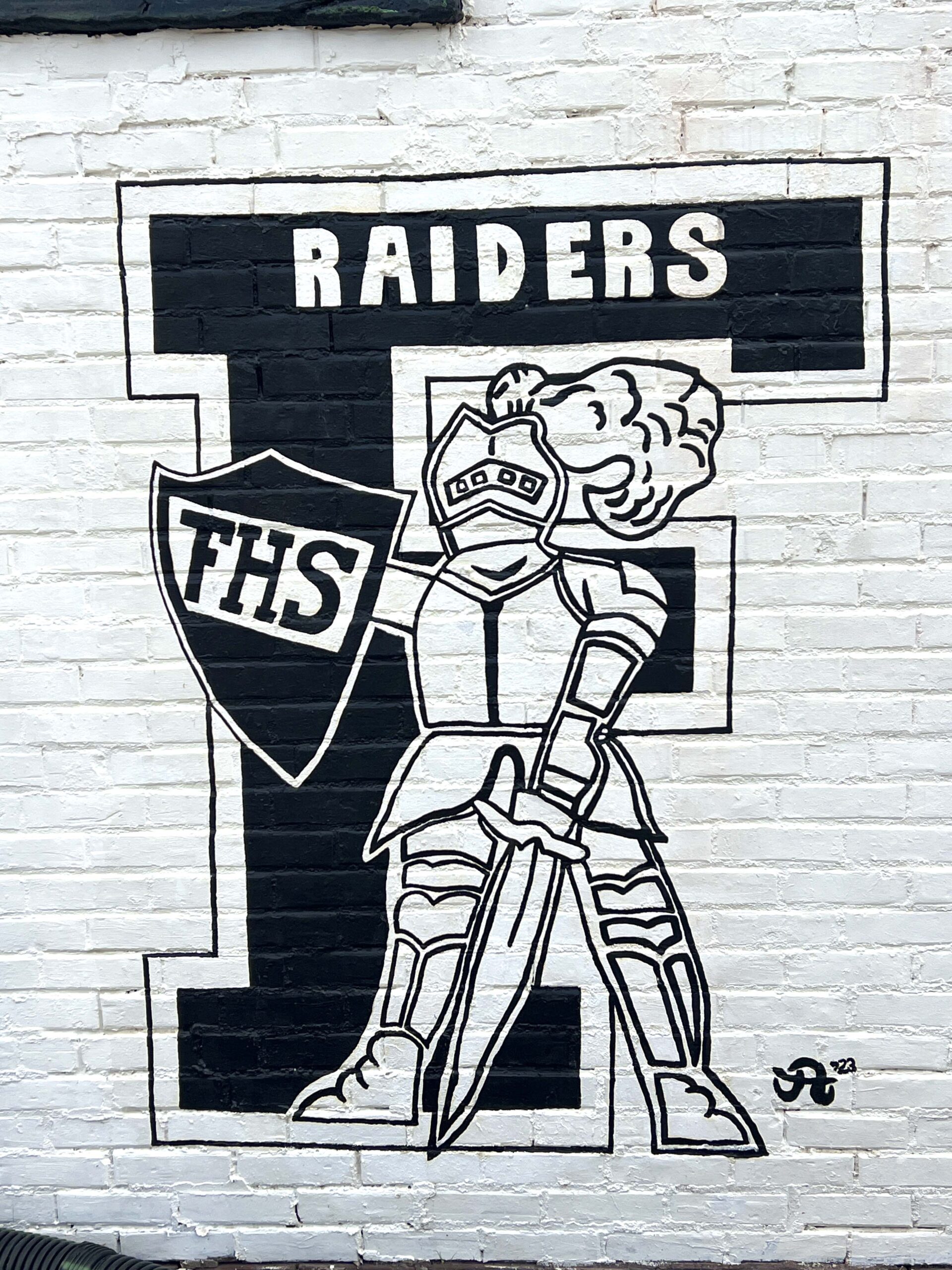A mural depicting the Frontenac Raiders is painted on the side of a downtown building to represent the town's pride for its students and athletic programs.