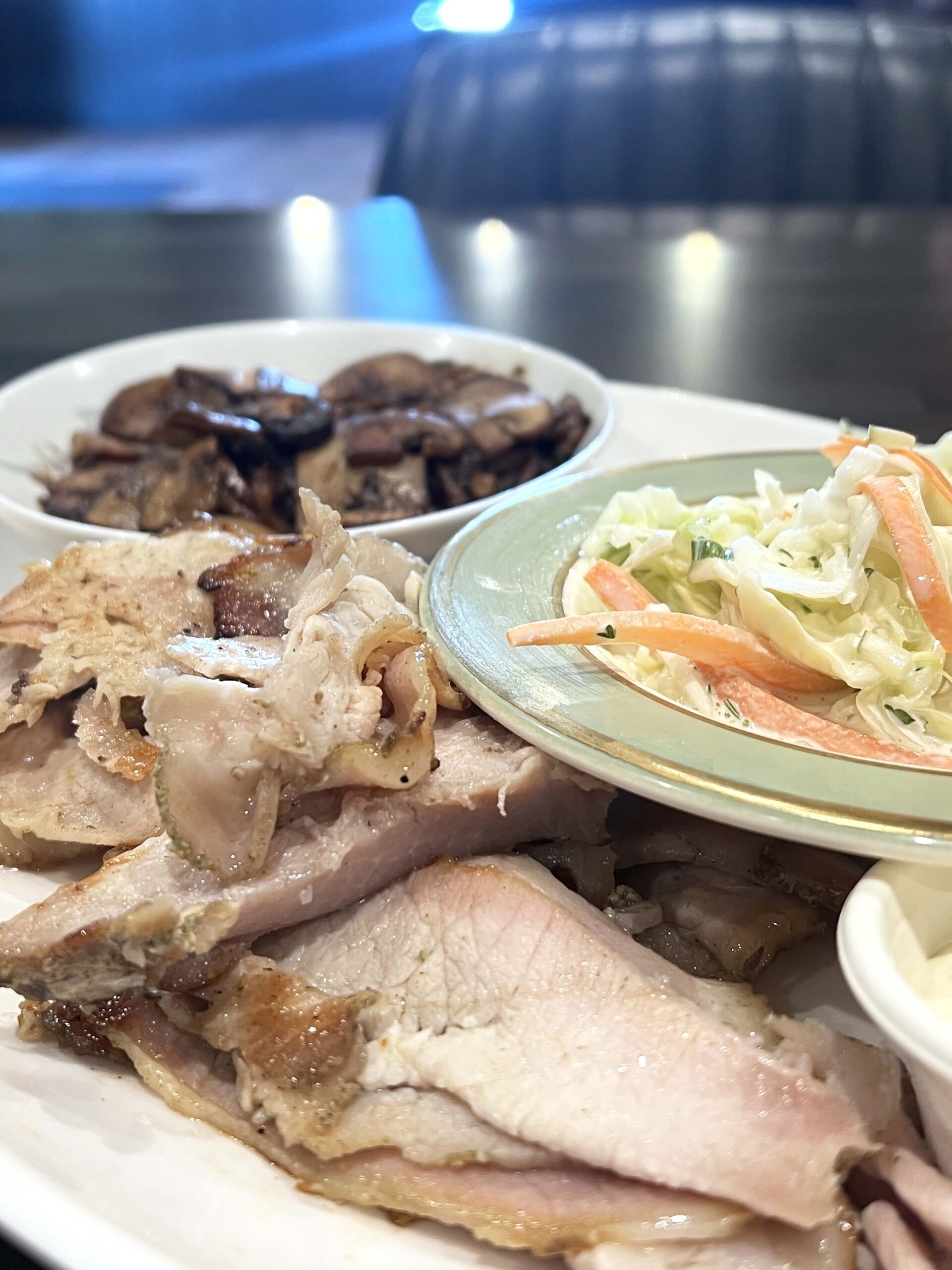 Smoked meats are served with scratch-made cole slaw and savory mushrooms.