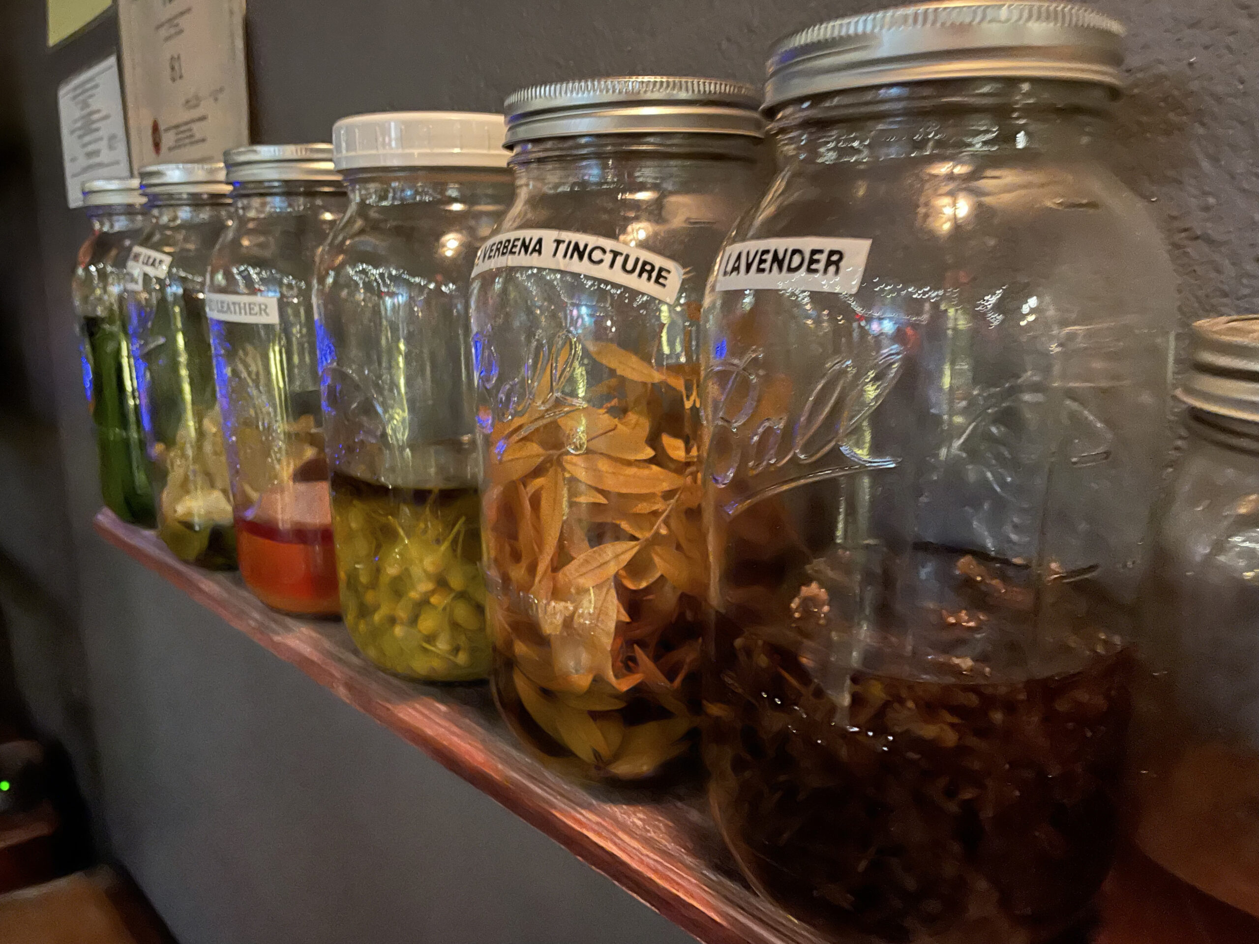 House-made infused spirits rest on a shelf