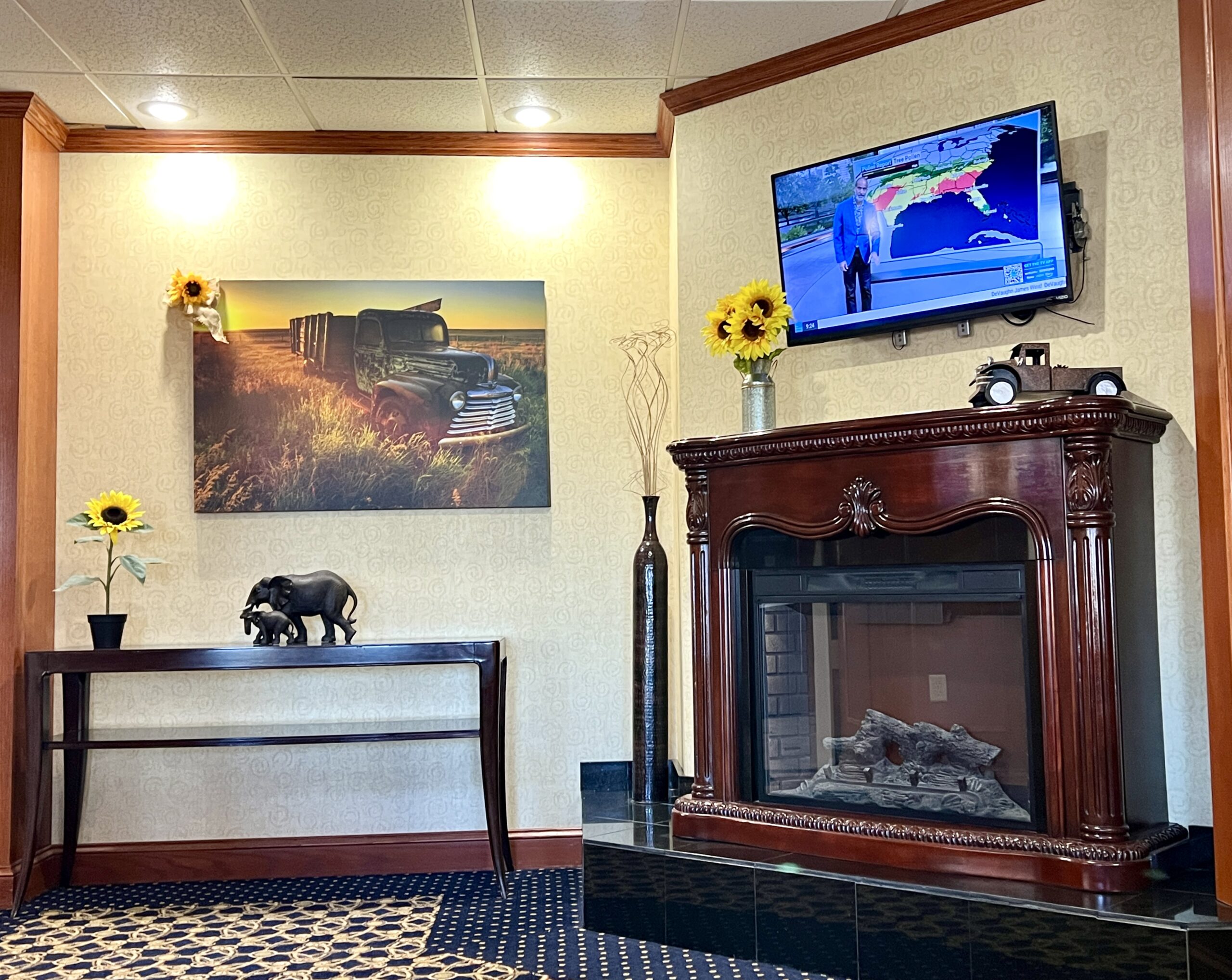 Baymont at Wyndham Pratt encourages guests to relax in the lobby near the fireplace. 