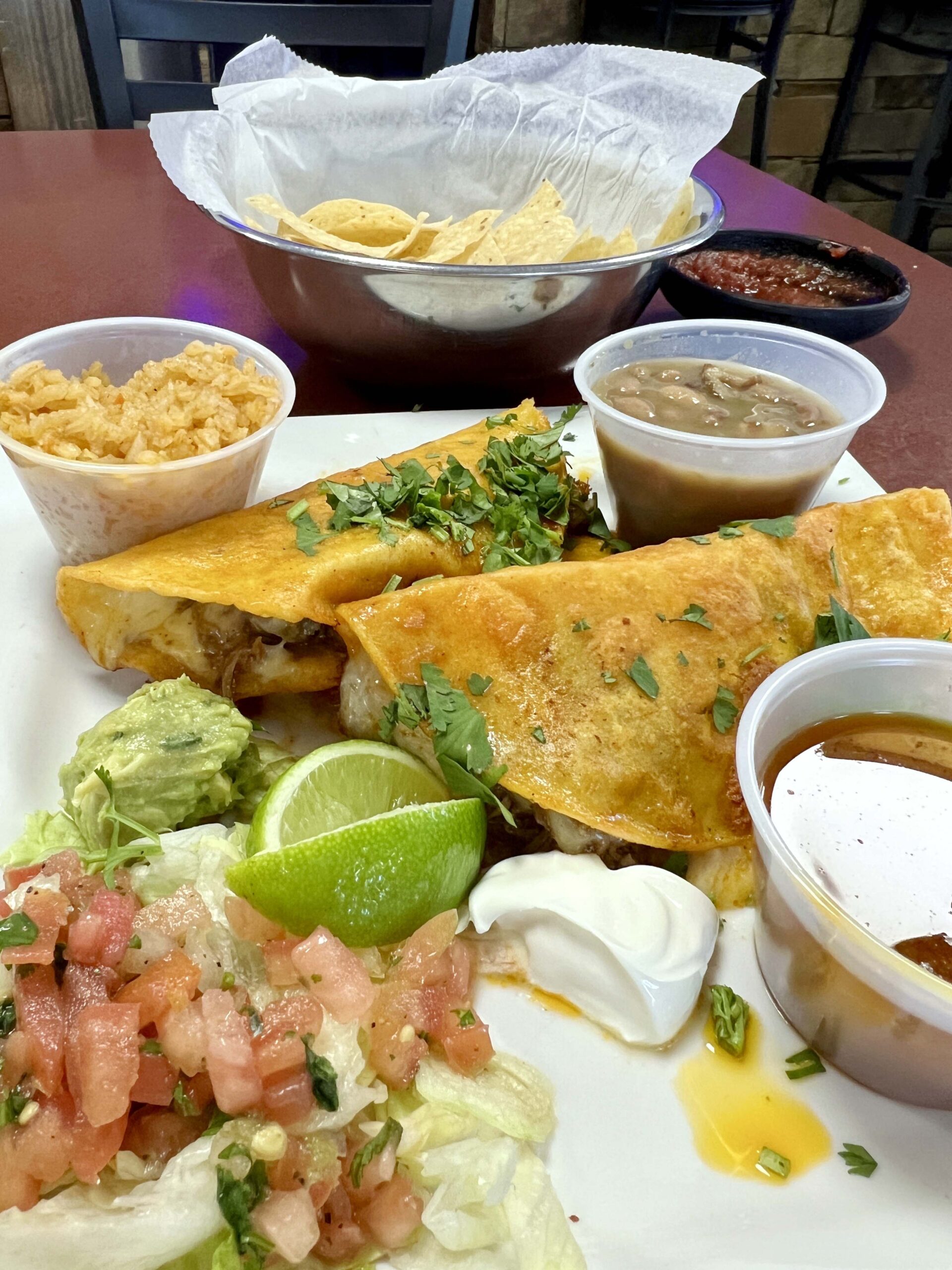 Queso Birria tacos come with pico de gallo, beans, and rice at Fronteras Mexican Restaurant in Ottawa, Kansas. 