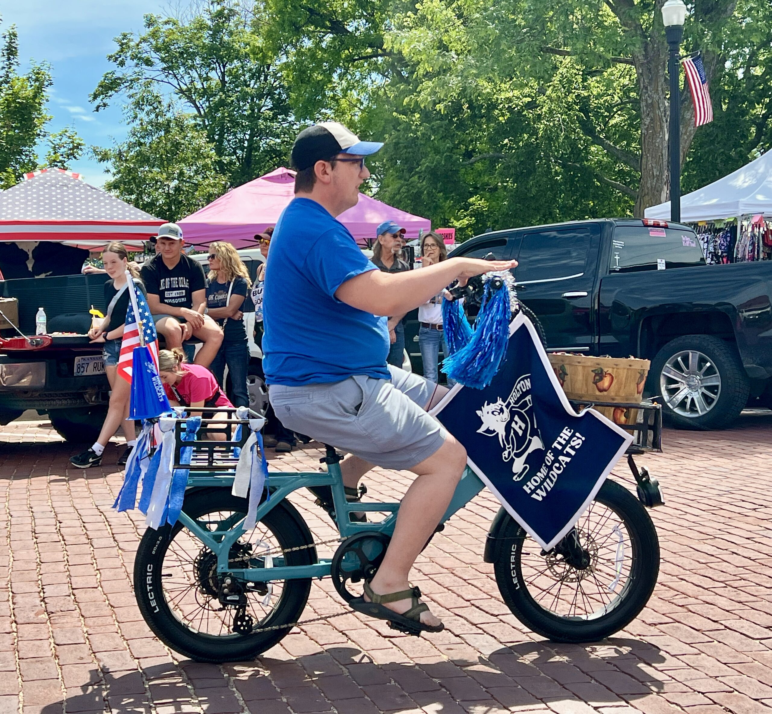 A man on a bike rides in the alumni parade.