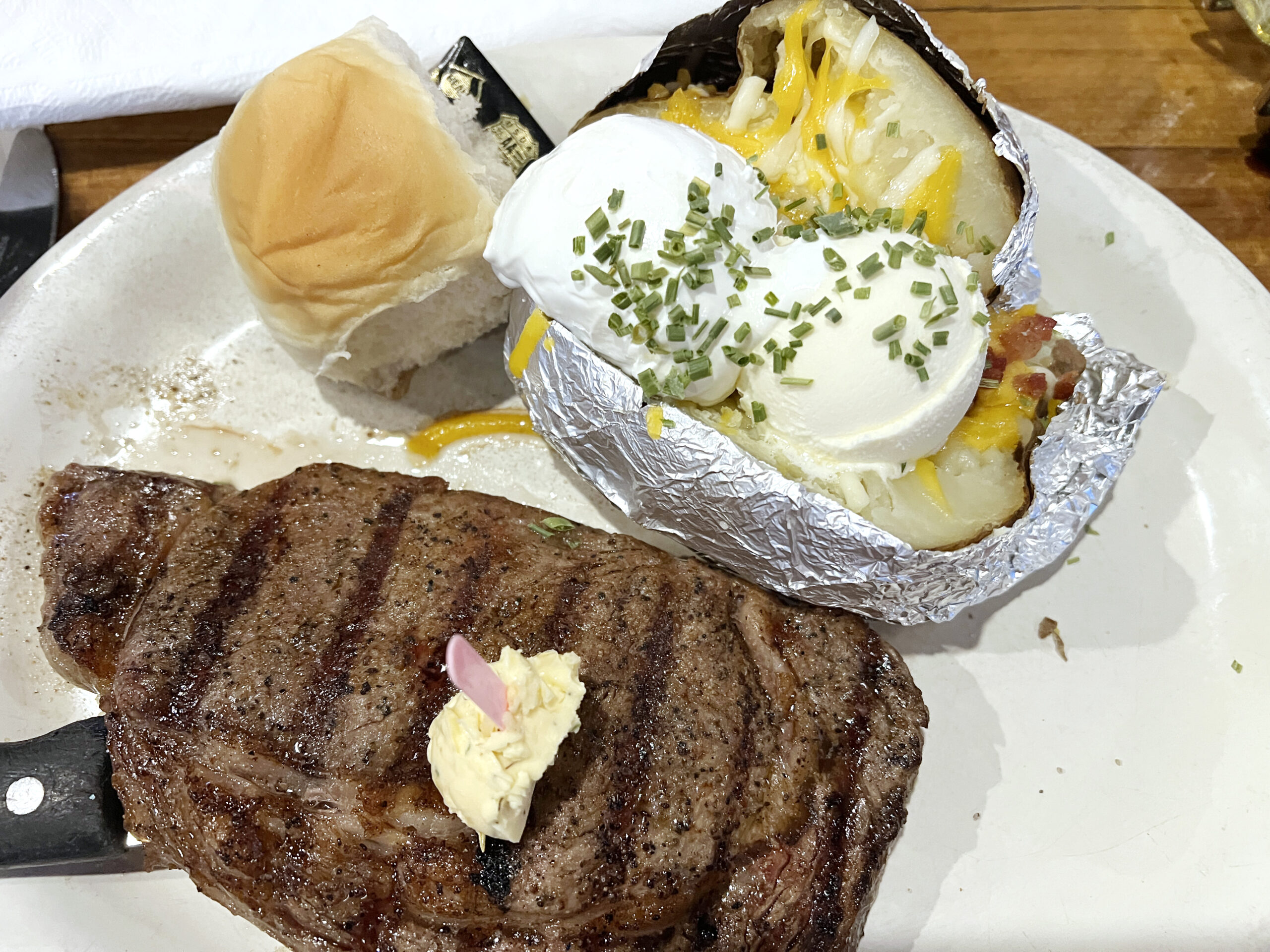 Ribeye Steak and a side of potato with roll is a dinner menu staple at Boomer's in Holton, Kansas.